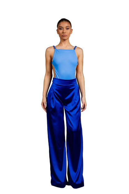 A model wearing a blue spandex backless bodysuit with blue agate and blue jade beadwork, paired with blue satin wide-leg high-waist trousers.